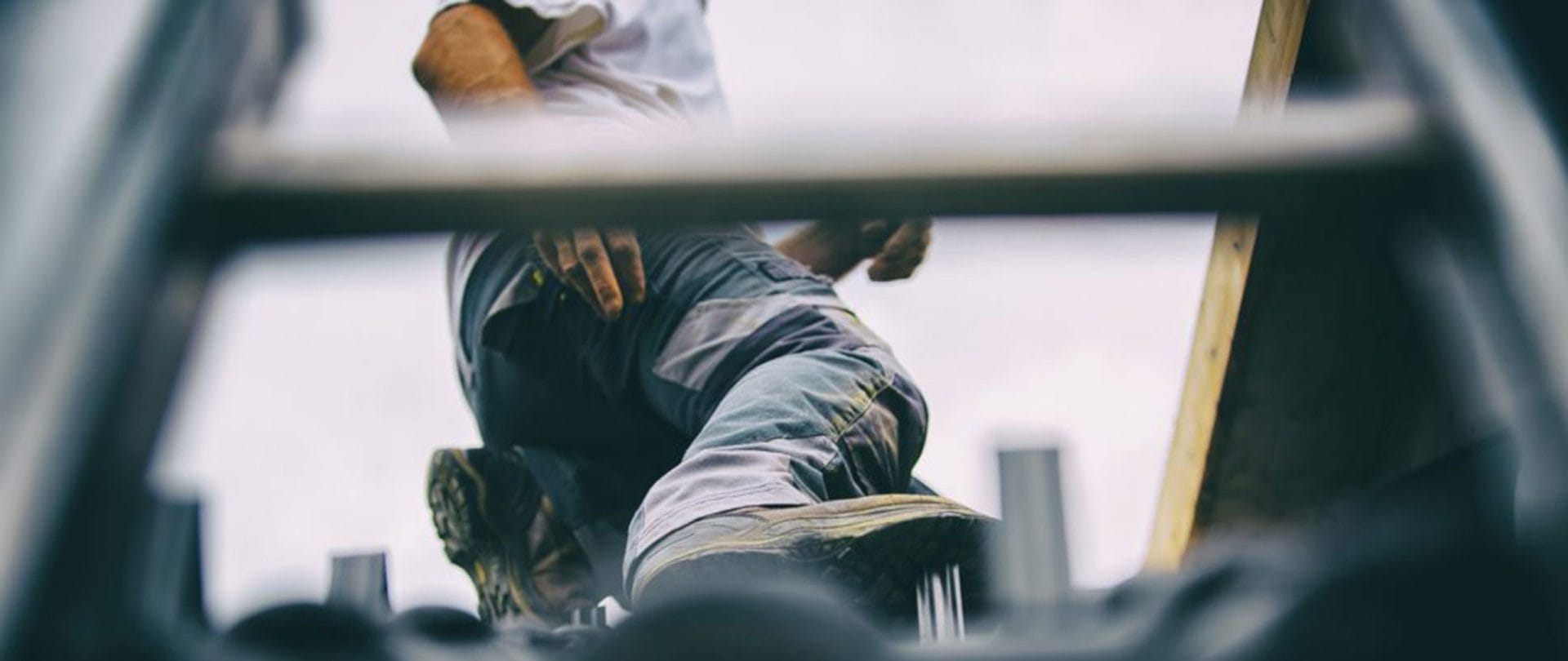 En medarbejder i arbejdstøj fotograferet nedenfra står et niveau højere