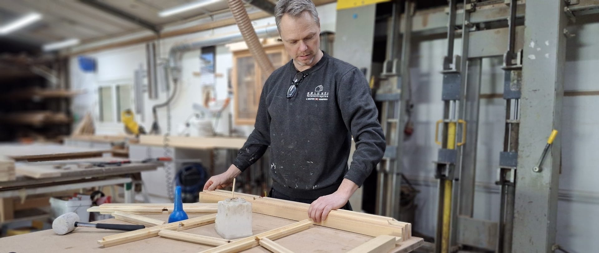 En medarbejder bearbejder trælameller i et værksted.